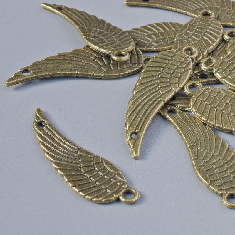 Zawieszka ozdobna «Skrzydło», średnica 30×9 mm, średnica otworu 1,6 mm, opakowanie 15 szt. +/-, kolor metalu brązowy