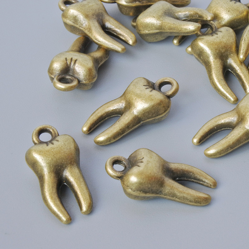 Zawieszka ozdobna „Ząb”, średnica 15,5 × 7,5 mm, średnica otworu 1,6 mm, opakowanie 15 szt. ±, brązowy kolor metalu
