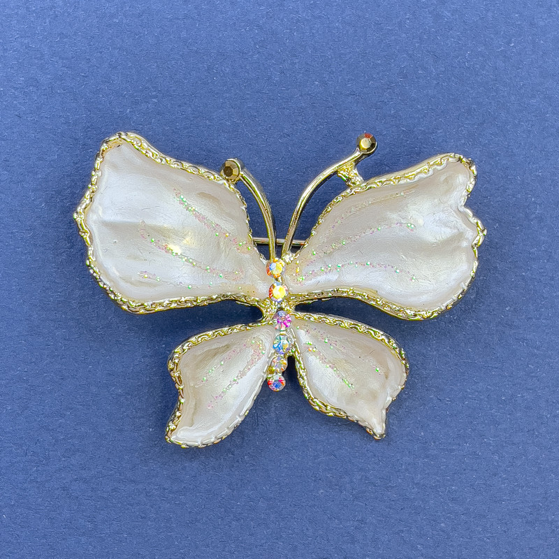Broszka Motyl z białymi kryształkami strass, kolor złocisty metalu, średnica 44 mm +/-, długość 33 mm+