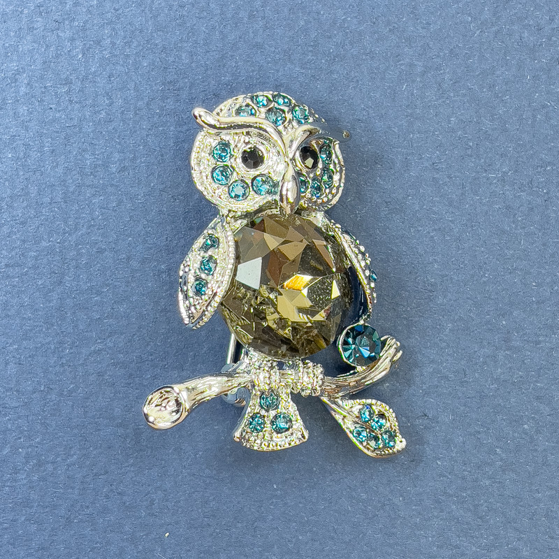 Broszka-wisiorek Sowa z błękitnymi strassami i szarym kryształem, srebrzysty metal, średnica ok. 26 mm, długość ok. 36 mm