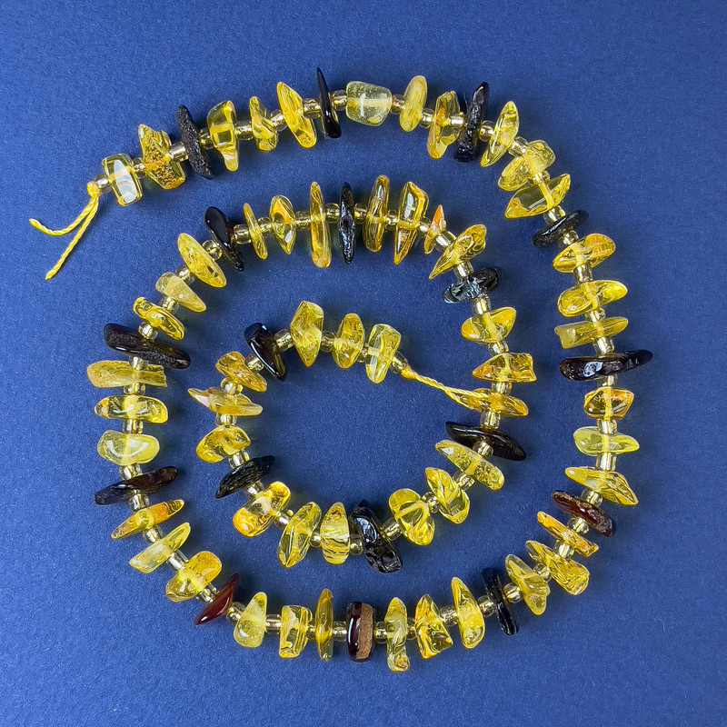Koraliki bursztynu – kruszynki 10–12×4 mm ± z drobnymi koralikami, średnica 3 mm ± na nici, długość 38 cm ±