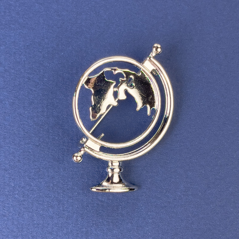 Broszka Globus z srebrzystego metalu 37×26 mm