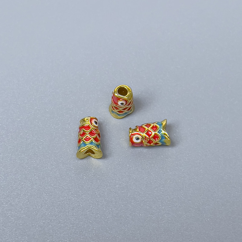 Koralik Cloisonné cylindryczny – rybka, czerwono-zielona emalia, średnica 4×7 mm, otwór 1,5 mm, złoty kolor metalu, 1 szt.