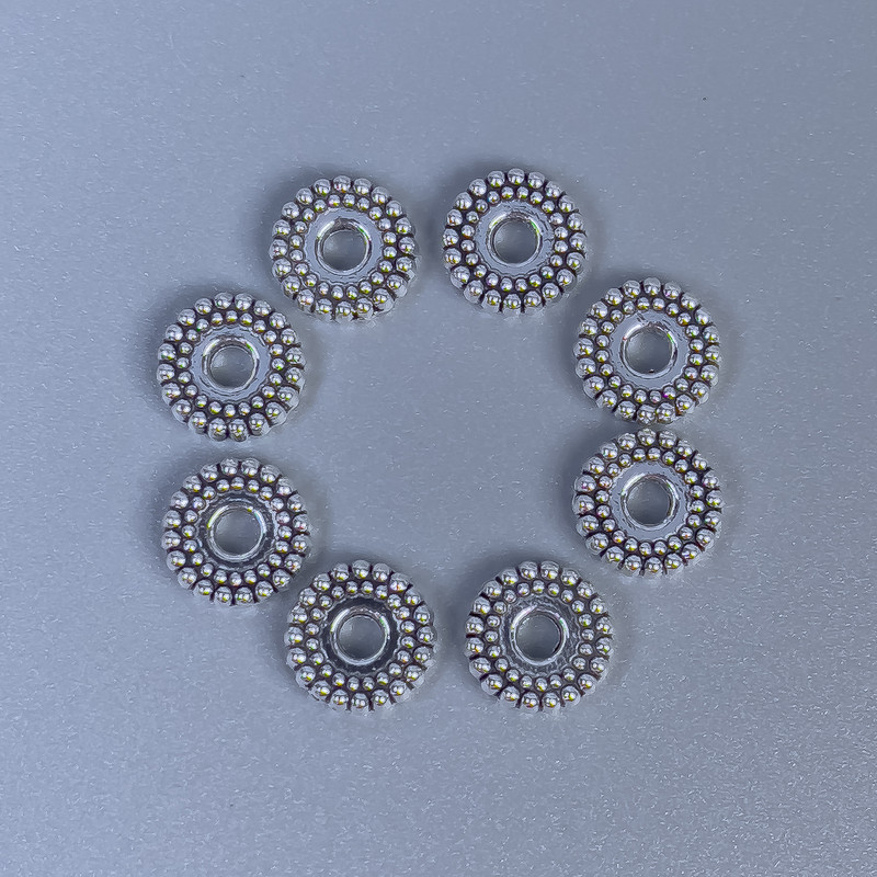 Koralik-wkładka, kolor metalu: srebrny, średnica 7×2 mm, otwór około 2 mm, opakowanie 20 g (~50 szt.)