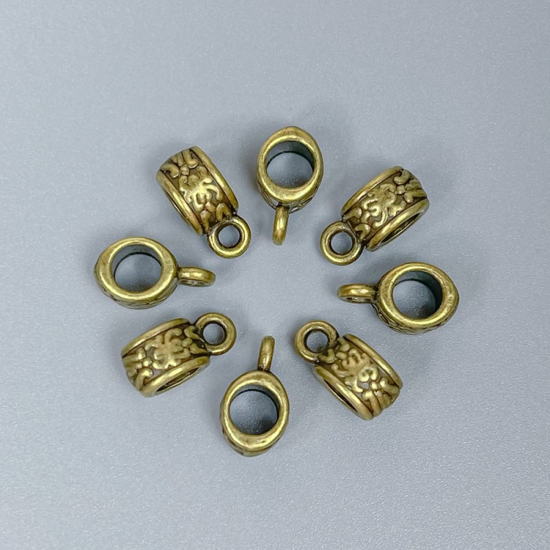 Zawieszka typu bail w kolorze brązu, wymiary 11×6×5 mm ±, średnica otworów 4,5 mm ± i 2 mm ±, opakowanie 20 szt.
