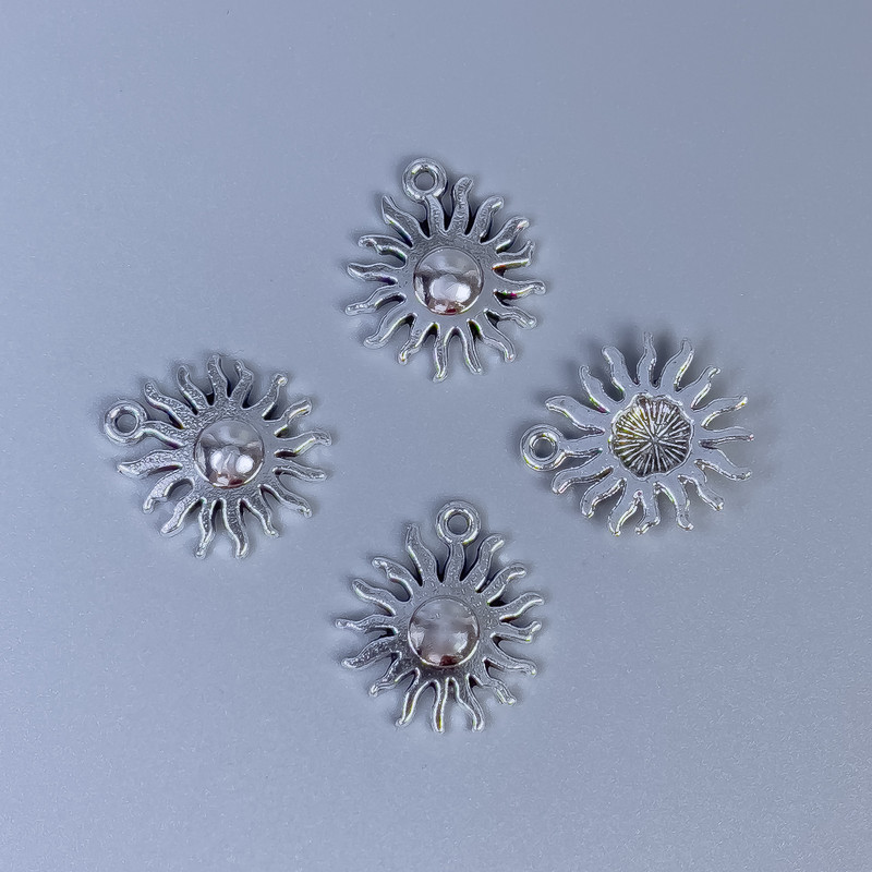 Zawieszka Słońce w kolorze srebra, rozmiary 17x15x2 mm, otwór 5 mm ±, średnica 1 mm ±, opakowanie 14 szt.