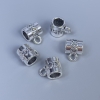 Zawieszka typu bail, kolor metalu: srebro, wymiary 9×8×7 mm ±, otwory 5 mm i 2 mm ±, opakowanie 14 szt.