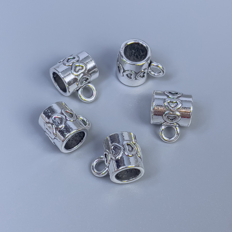 Zawieszka typu bail, kolor metalu: srebro, wymiary 9×8×7 mm ±, otwory 5 mm i 2 mm ±, opakowanie 14 szt.