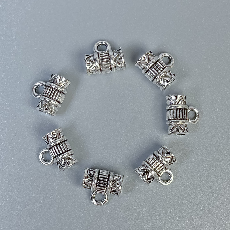 Zawieszka bail w kolorze srebra, wymiary 8×8×4 mm ± otwory, średnica 3 mm ±, średnica 1,8 mm ±, opakowanie 20 g (~45 szt.)