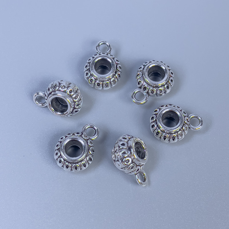 Zawieszka bail kolor metalu: srebro, wymiary 11 x 8 x 6 mm (+/-); otwory średnica 3,5 mm (+/-), średnica 2 mm (+/-); opakowanie 20 g (~18 szt.)