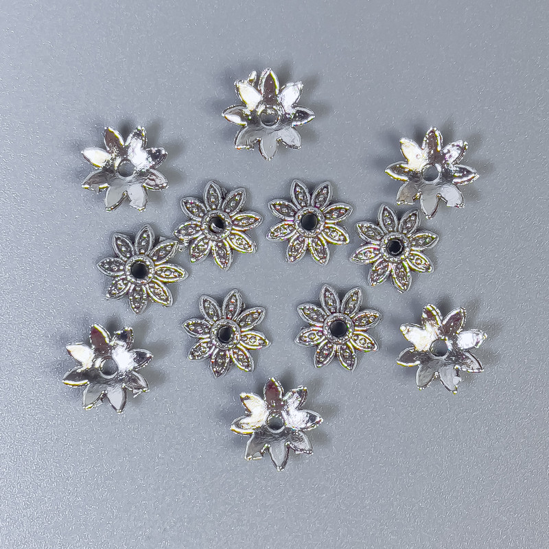 Czapeczki do koralików w kolorze metalu – srebro, średnica 7×0,5 mm, otwór 1 mm ±, opakowanie 70 szt.