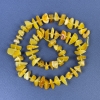 Koraliki bursztynu – drobinki 9–14×3–6 mm z koralikami o średnicy 3 mm na nitce, długość 38 cm