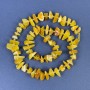 Koraliki bursztynu – drobinki 9–14×3–6 mm z koralikami o średnicy 3 mm na nitce, długość 38 cm