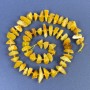 Koraliki bursztynowe – drobne kawałki bursztynu o wymiarach 9–12×3–5 mm ± z koralikami 2,5 mm ± na nici, długość 39 cm ±