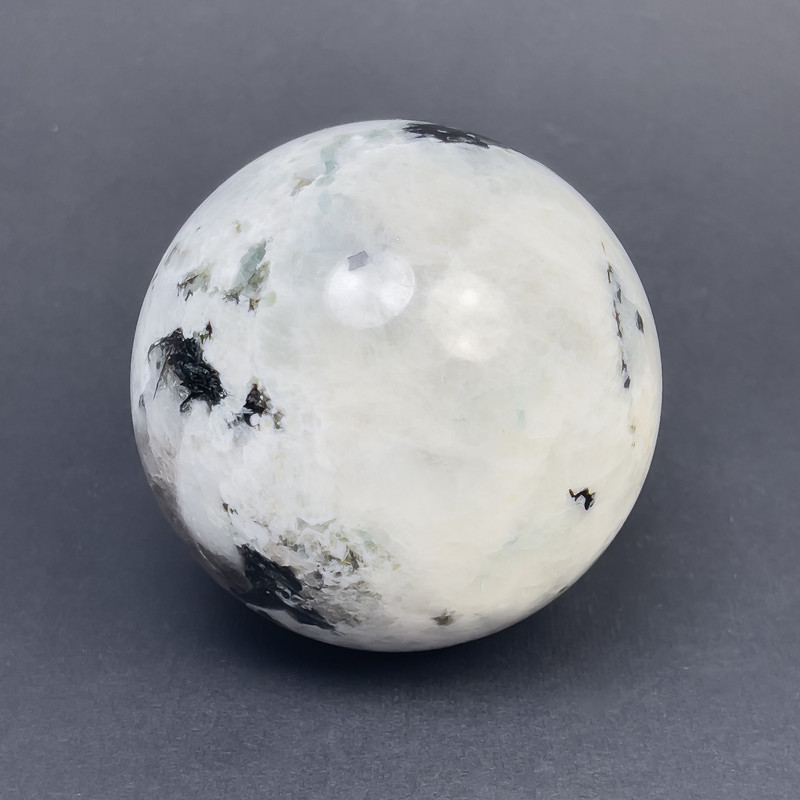 Cena za 100 g. Kula z adularu z pyrytu i turmalinu, rozmiary ~66 mm, waga ~300 g