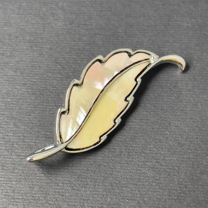 Broszka-kulon z perłowym połyskiem srebrzystego metalu 51×17 mm+