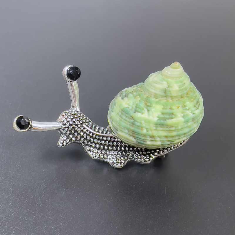 Broszka-wisiorek Ślimak, zielony kolor, metal srebrzysty, 53×26 mm ± czarne kryształy