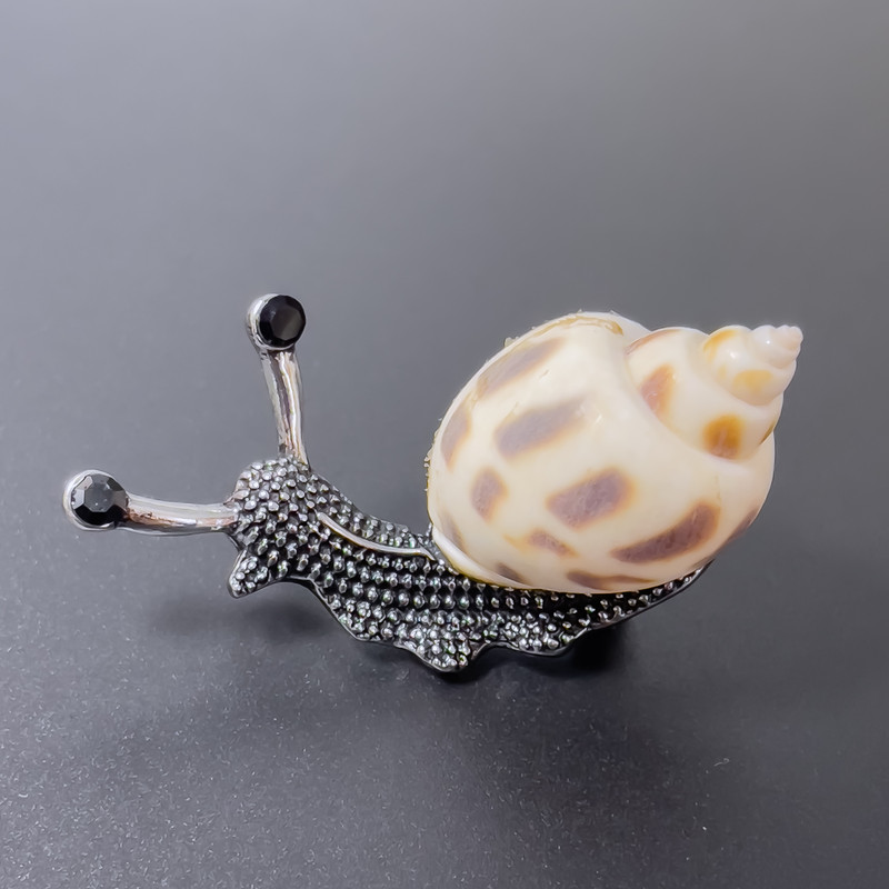 Broszka-wisiorek Ślimak biały z brązowym odcieniem, metal srebrzysty, 53×26 mm +- czarne kryształy