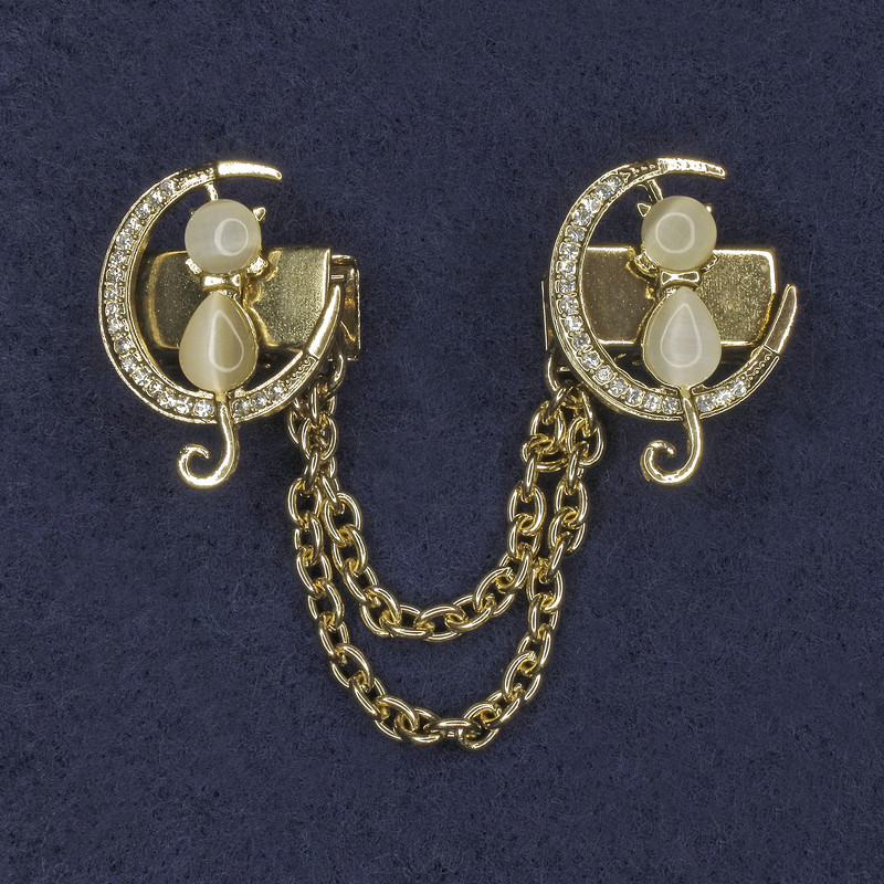 Broszka do kardiganów „Białe Kocie Oko”, średnica około 20×27 mm, białe cyrkonie, metal złocisty, łańcuszek, długość około 9 cm.