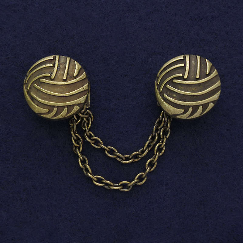 Broszka do kardiganów w kolorze brązu, średnica około 20 mm, długość łańcuszka 9 cm.