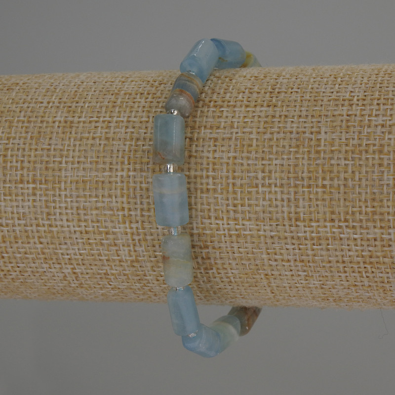 Bransoleta z błękitnego kalcytu — cylindryczne koraliki o wymiarach 10×6 mm, drobne koraliki 3 mm, długość około 18 cm, elastyczna