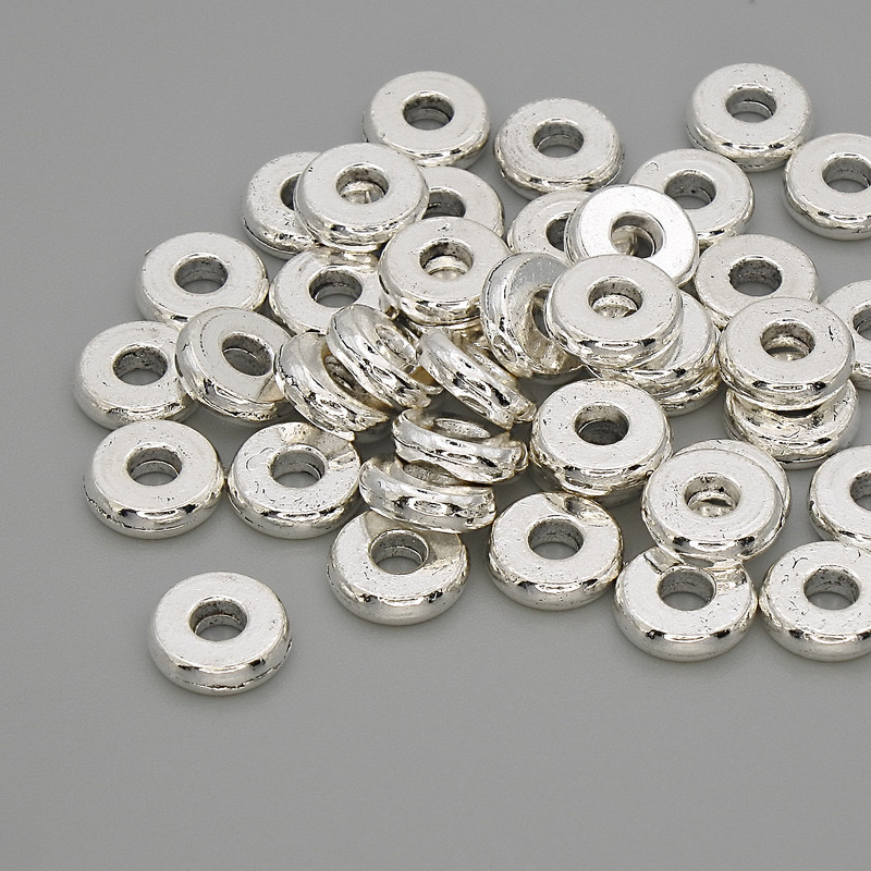 Koralik-wstawka w kolorze metalu srebrnym, średnica 7,5×2 mm, otwór 2,5 mm, opakowanie 20 g (~40 szt.)