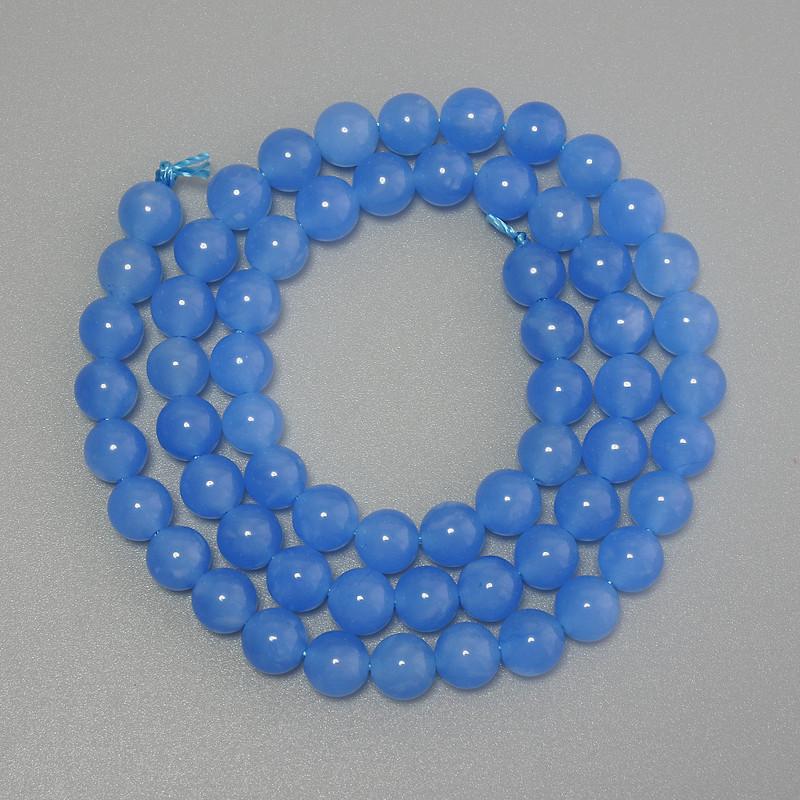 Koraliki akwamarynu — gładkie kuleczki, średnica 6 mm, na nici, długość 38 cm.