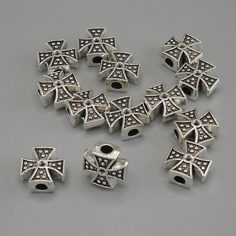 Koralik-wkładka w kształcie krzyża, kolor metalu srebrny, o wymiarach około 11×11×5 mm, otwór Ø około 3 mm, opakowanie 20 g (~13 szt.)