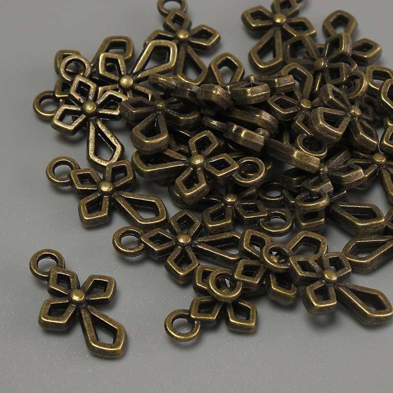 Zawieszka w kształcie krzyża, kolor brązowy, metalowy; wymiary 16×10×2 mm, otwór 2 mm, opakowanie 20 g (~31 szt.)