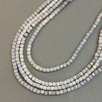 Koraliki czeskiego kryształu szare z powłoką benzynową na nici, kostki fasetowane o wymiarach 4×4 mm, długość 38 cm