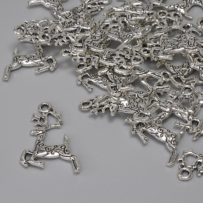 Wisiorek – Jeleń, kolor metalu: srebrny, średnica 22×13 mm, otwór 1,6 mm, opakowanie 25 szt.