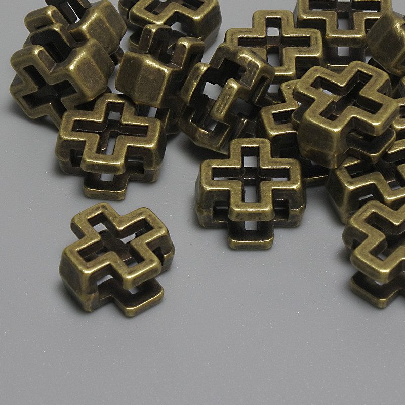Koralik-wkładka w kształcie krzyża, kolor metalu: brązowy, wymiary 10×10×5 mm; otwór 5 mm ±; wymiary 7×2, 7 mm ±; opakowanie 15 szt. +