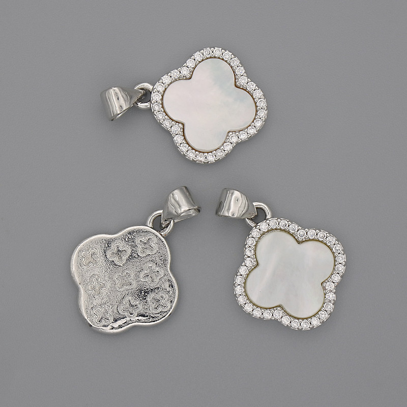 Wisiorek z perłowym połyskiem w formie czterolistnej koniczyny z białymi cyrkoniami, 15×15 mm, długość 22 mm, metal w kolorze srebra