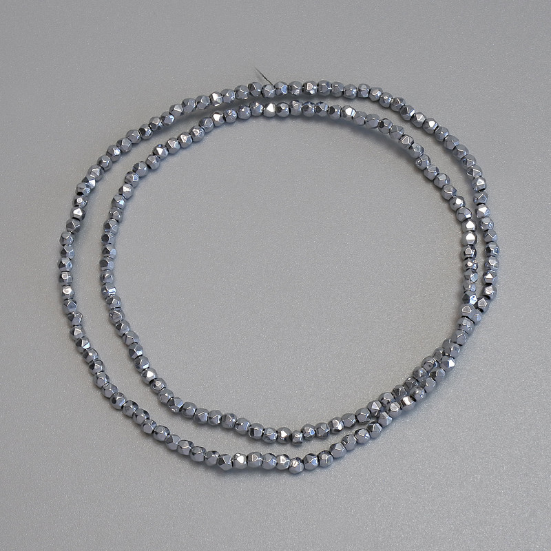 Koraliki hematytu w kolorze srebra, wielokąty 2x2 mm, na żyłce, długość 38 cm.