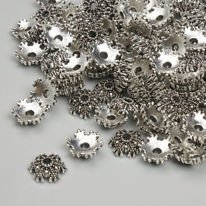 Furnitura: czapeczka do koralika, średnica 7 mm ± otwór, średnica 1,5 mm ± srebrzysty kolor metalu, opakowanie 20 g (~99 szt.)