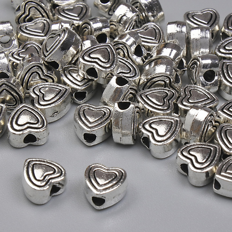 Koralik-wstawka w kształcie serca, kolor metalu: srebrny, średnica 6 mm ± otwór, średnica 1,6 mm ± opakowanie 20 g (~45 szt.)