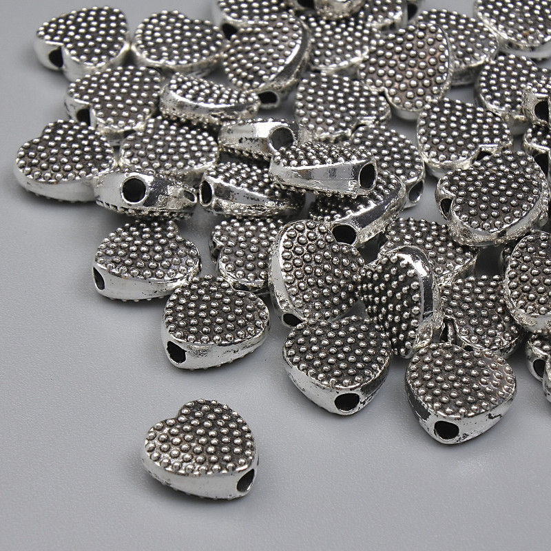 Koralik-wstawka w kształcie serca, kolor metalu srebrny, średnica 7 mm ±, otwór 1,3 mm ±, opakowanie 20 g (~40 szt.)