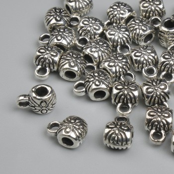 Zawieszka bail w kolorze metalu srebrzystym, wymiary 8×4,5 mm +/- otwory Ø 2 mm +/- Ø 3 mm +/- opakowanie 26 szt.
