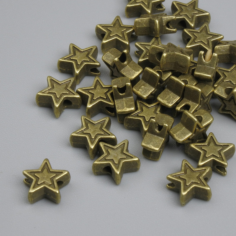 Koralik-wkładka w kształcie gwiazdki, kolor metalu brązowy antyczny, średnica 6×2,5 mm, otwór 1,5 mm, opakowanie ~25 szt. +