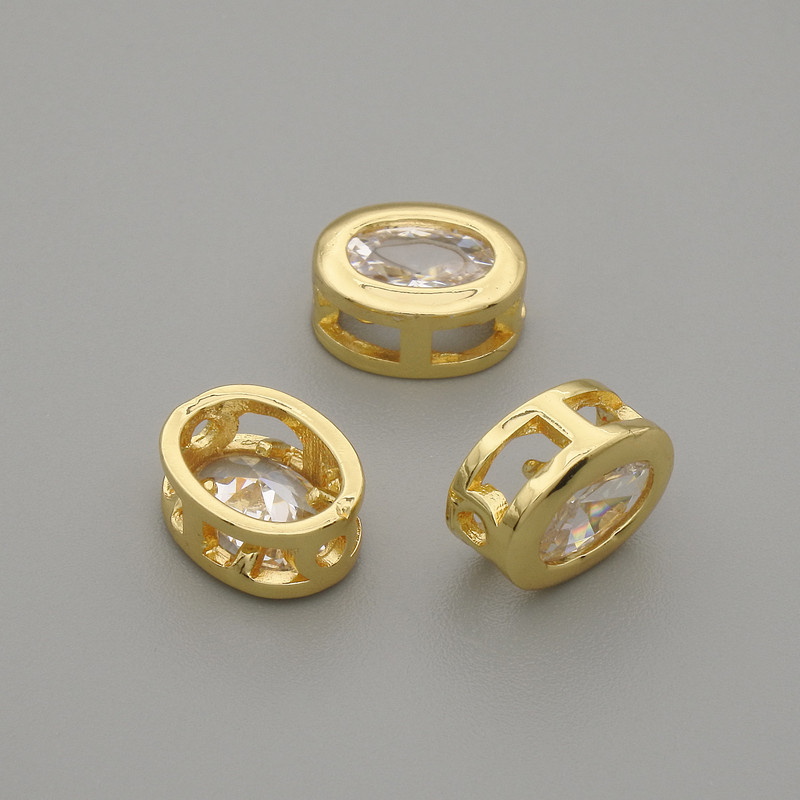 Koralik-wstawka z białego kryształu w złotej oprawie, owalny, wymiary 9×7 mm, otwór Ø 1,3 mm, za 1 szt.