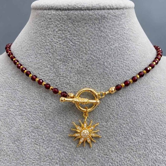 Choker z fasetowanymi kulkami granatu 4 mm ± i hematytu 2 mm ±, z wisiorkiem w kształcie słońca o średnicy około 20 mm ±, długość 37 cm ±, zapięcie typu toggle
