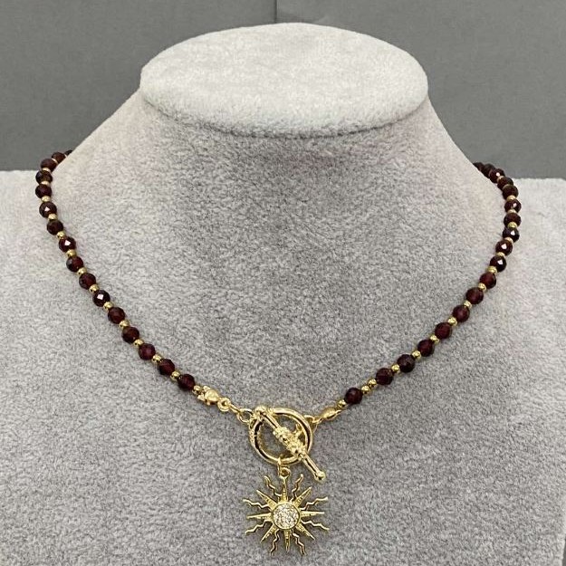 Choker z fasetowanymi kulkami granatu 4 mm ± i hematytu 2 mm ±, z wisiorkiem w kształcie słońca o średnicy około 20 mm ±, długość 37 cm ±, zapięcie typu toggle