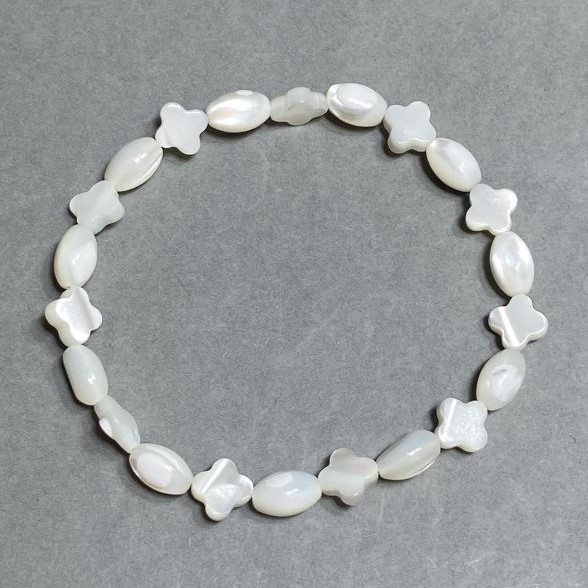 Bransoletka z masy perłowej z koniczyną (fasetowane ziarno) 9x6 mm +-koniczynka 8 mm+-, długość 18 cm+- na gumce (stretch)