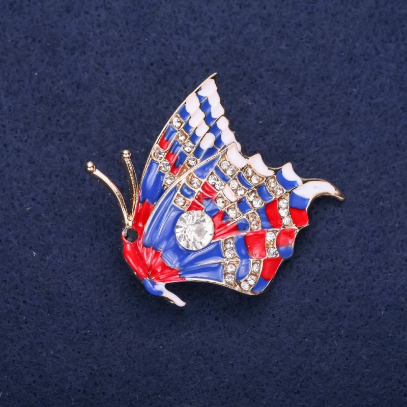 Broszka «Motyl» z białymi kryształami, niebieską i czerwoną emalią, o rozmiarach 40×38 mm, metal w kolorze żółtym