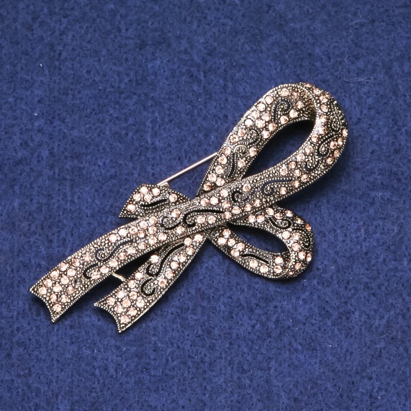 Broszka w formie kokardy z złotymi cyrkonami, złoty metal 39×80 mm