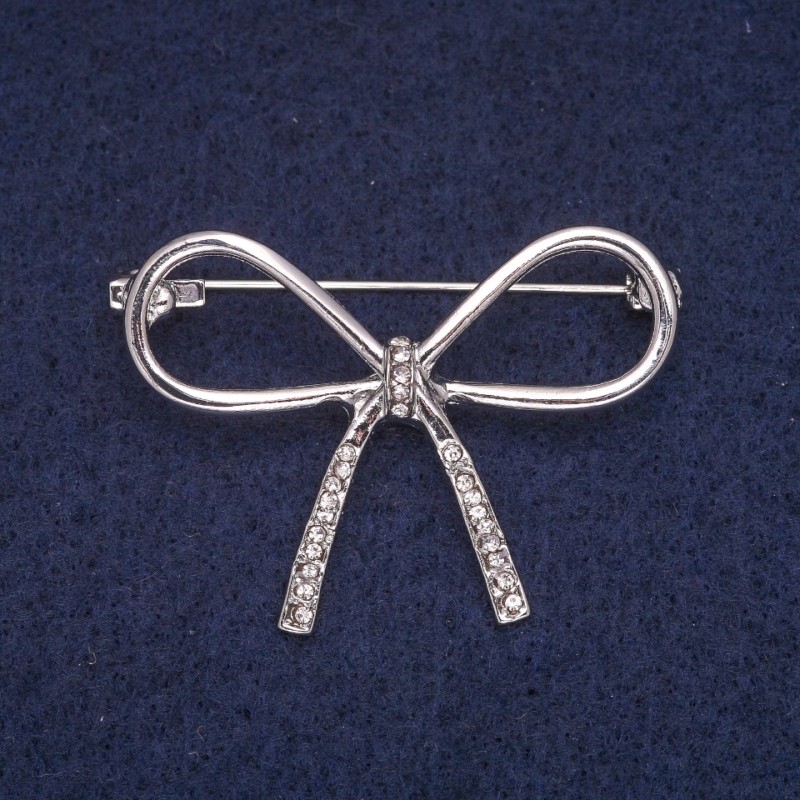 Broszka w formie kokardy z białymi kryształami, metal srebrzysty 30×41 mm