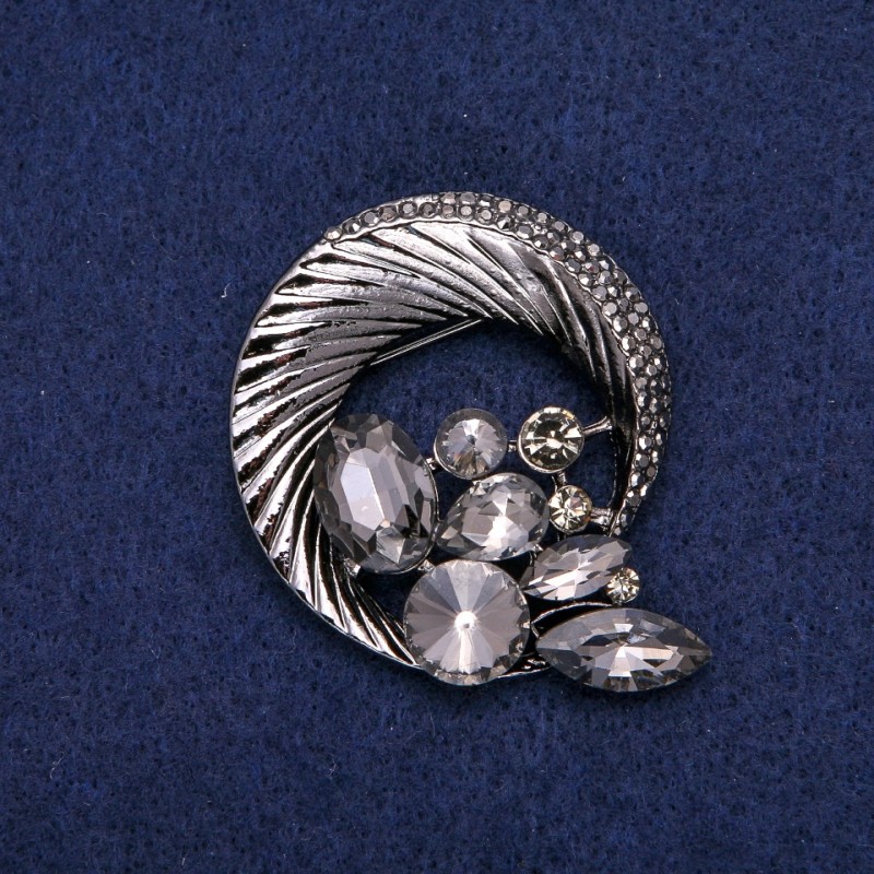 Broszka okrągła z obwódką z cyrkoniami, splatająca się w piękną kompozycję, ciemny metal 45×50 mm