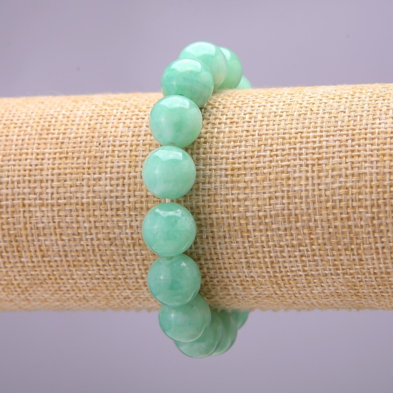 Bransoletka z naturalnego kamienia — birmański jadeit, gładkie kuleczki o średnicy około 12 mm, na elastycznej gumce, długość 18 cm