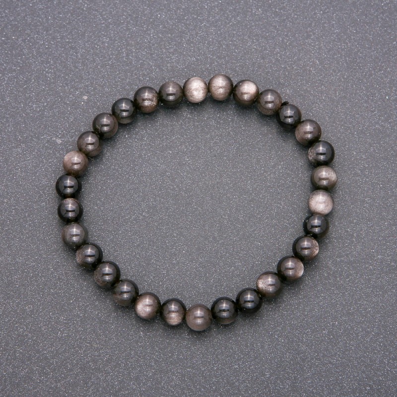 Bransoletka z naturalnego kamienia, srebrzysty obsydian na gumce, gładkie kulki o średnicy około 6 mm, długość 18 cm