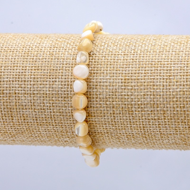 Bransoletka na gumce z naturalnego beżu perłowego. Okrągłe fasetowane koraliki, średnica 7×5 mm+
